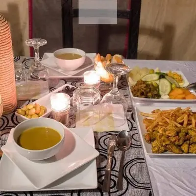 a table with plates of food and a bowl of soup at Sahara Family Luxury Camp in Merzouga