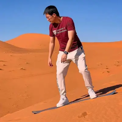 a man standing in the sand in the desert at Sahara Family Luxury Camp in Merzouga