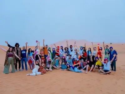 a group of people posing for a picture in the desert at Sahara Family Luxury Camp in Merzouga