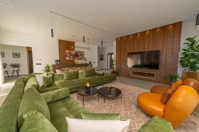 a living room with green couches and a television at Villa Marrakech vue atlas in Marrakech
