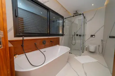 a bathroom with a tub and a shower and a window at Villa Marrakech vue atlas in Marrakech