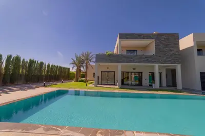 a swimming pool in front of a house at Villa Marrakech vue atlas in Marrakech