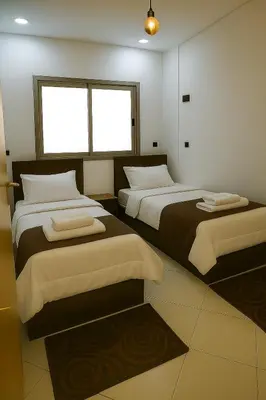 a bedroom with two beds and two windows at Appartement avec un style de chalet in Azrou