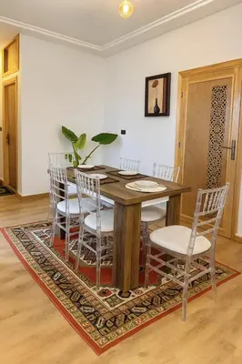 a dining room with a wooden table and chairs at Appartement avec un style de chalet in Azrou