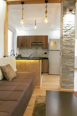 a living room with a couch and a kitchen at Appartement avec un style de chalet in Azrou