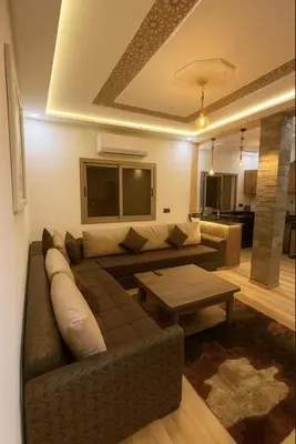 a living room with a couch and a table at Appartement avec un style de chalet in Azrou