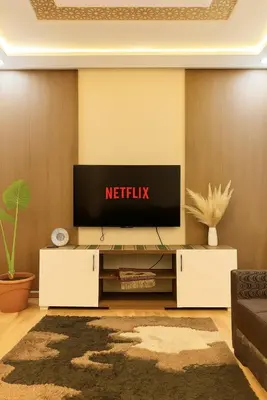 a living room with a television on a wall at Appartement avec un style de chalet in Azrou