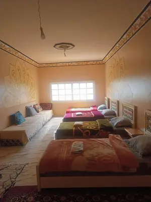 a room with four beds and a couch at Ait Ayoub Voyages in Azilal