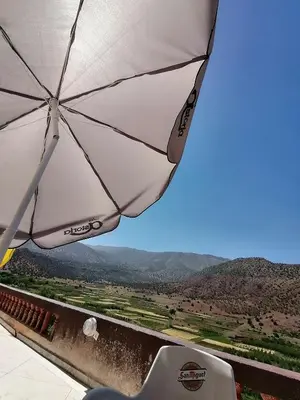 a white umbrella sitting on top of a balcony at Ait Ayoub Voyages in Azilal