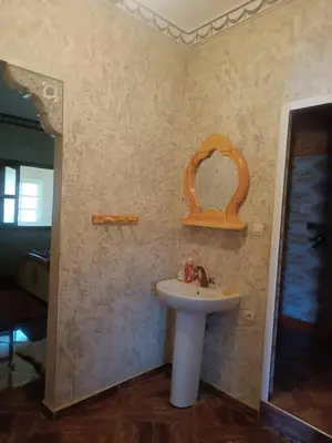 a bathroom with a sink and a mirror at Ait Ayoub Voyages in Azilal