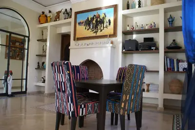 a dining room with a table and chairs and a fireplace at La Kasbah Aalma D'or in Najem