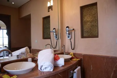 a bathroom with two sinks and a large mirror at La Kasbah Aalma D'or in Najem