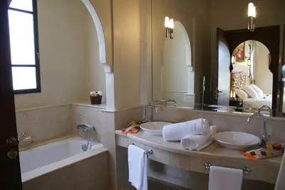 a bathroom with two sinks and a tub and a mirror at La Kasbah Aalma D'or in Najem