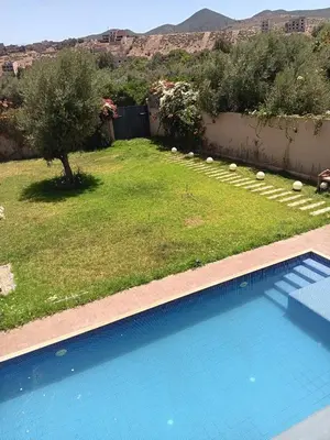 a swimming pool in a yard with a field of grass at Villa Jamel Marrakech Zac in Marrakech
