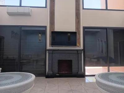 a living room with a fireplace with a flat screen tv at Villa Jamel Marrakech Zac in Marrakech