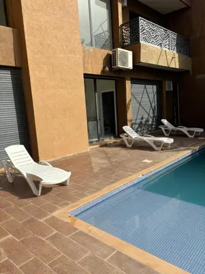 a swimming pool with two lounge chairs next to a building at Villa Jamel Marrakech Zac in Marrakech