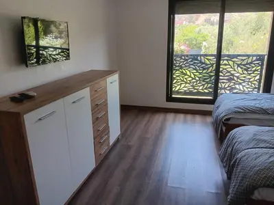 a bedroom with two beds and a dresser and two windows at Villa Jamel Marrakech Zac in Marrakech