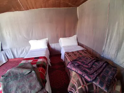 a small room with two beds in a tent at Unforgettable Nights in Merzouga in Merzouga