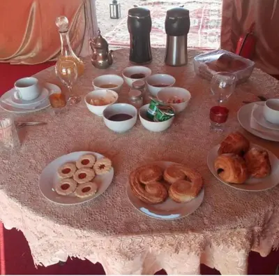 a table topped with plates of donuts and other foods at Unforgettable Nights in Merzouga in Merzouga