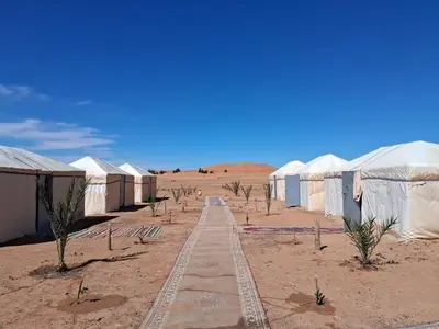 a row of tents in the middle of the desert at Unforgettable Nights in Merzouga in Merzouga