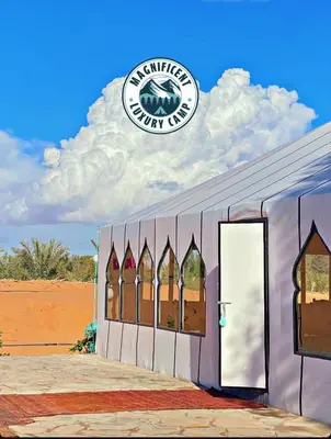 a building with a sign on the side of it at Magnificent Luxury Camp in Merzouga
