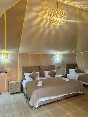 a bedroom with two beds in a tent at Magnificent Luxury Camp in Merzouga