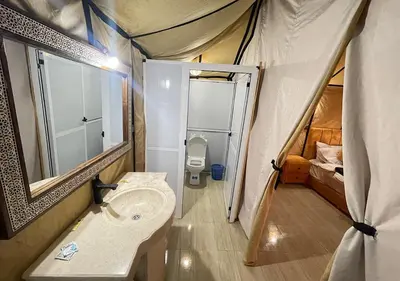 a bathroom with a sink and a toilet in a tent at Magnificent Luxury Camp in Merzouga