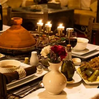 a table with plates of food and candles on it at Magnificent Luxury Camp in Merzouga