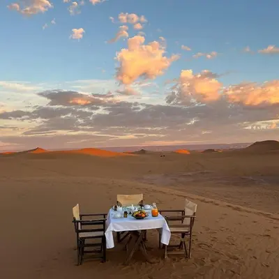 a table in the middle of the desert at Magnificent Luxury Camp in Merzouga