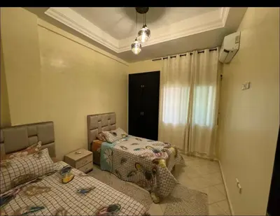 a bedroom with two beds and a couch in it at Downtown Fez Delight Apartment in Fès