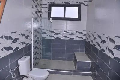 a bathroom with a toilet and a shower and a window at Amira Suite Double with Bathroom in Fès