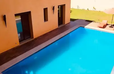 a swimming pool in front of a house at Villa de la famille, with Private pool in Marrakech