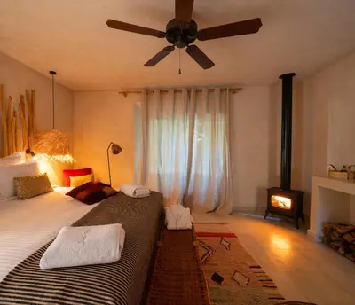 a bedroom with a large bed with a ceiling fan at Jardin Sakina - Séjour paisible avec soins bien-être, à 35 minutes de Marrakech in Marrakech