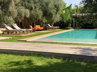 a swimming pool with lounge chairs and a picnic table at Jardin Sakina - Séjour paisible avec soins bien-être, à 35 minutes de Marrakech in Marrakech