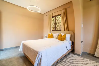a bedroom with a large bed with yellow pillows at Villa a Marrakech with private pool in Marrakech