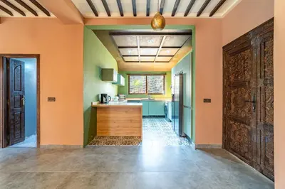 a kitchen with orange walls and a wooden door at Villa a Marrakech with private pool in Marrakech