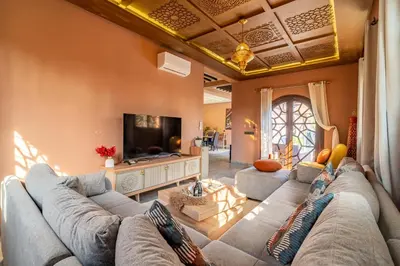 a living room with a couch and a tv at Villa a Marrakech with private pool in Marrakech