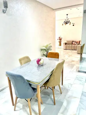 a dining room with a table and chairs at Luxueux Appartement Parc Champs de Cours avec Wifi Fibre 200 Mo in Fès