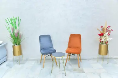 three chairs in a room with flowers in vases at Luxueux Appartement Parc Champs de Cours avec Wifi Fibre 200 Mo in Fès