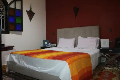 a bedroom with a large bed with a colorful blanket at Niche paradis in Aghmat