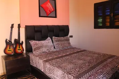 a bedroom with a bed with two guitars on the wall at Niche paradis in Aghmat