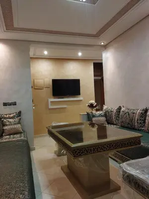 a living room with a couch and a tv at Appartement meublé fes in Fès