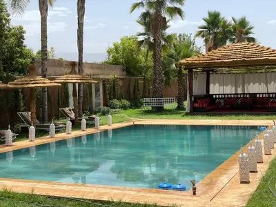 a swimming pool in a yard with a gazebo at Riad Marjana in Marrakech
