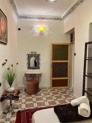 a room with a bed and a mirror and a table at Appartement Authentique à la Médina de Fès - À Deux Pas de Bab Bou Jeloud & des Souks in Fès al Bali