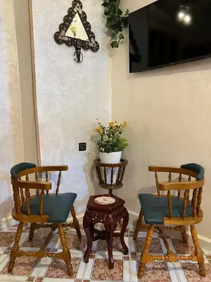 two chairs and a table with a plant on it at Appartement Authentique à la Médina de Fès - À Deux Pas de Bab Bou Jeloud & des Souks in Fès al Bali