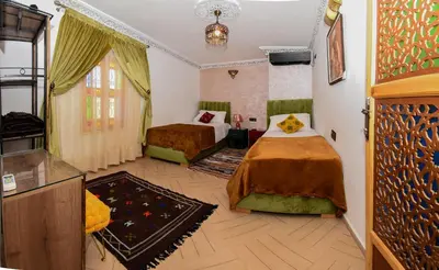 a hotel room with two beds and a tv at Appart Sahraoui Medina in Fès al Bali