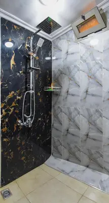 a shower with a black and white marble wall at Appart Sahraoui Medina in Fès al Bali