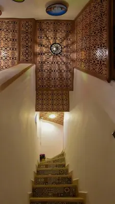a stairway with a clock on the wall and a clock on the ceiling at Appart Sahraoui Medina in Fès al Bali