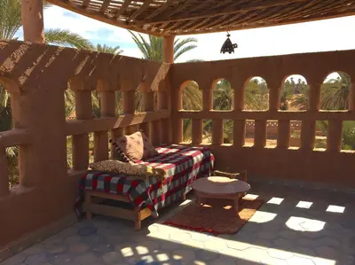 a porch with a chair and a table on a patio at Dar Sidi Bounou in Mhamid