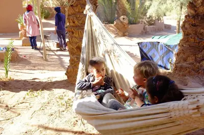 a group of children sitting in a hammock at Dar Sidi Bounou in Mhamid